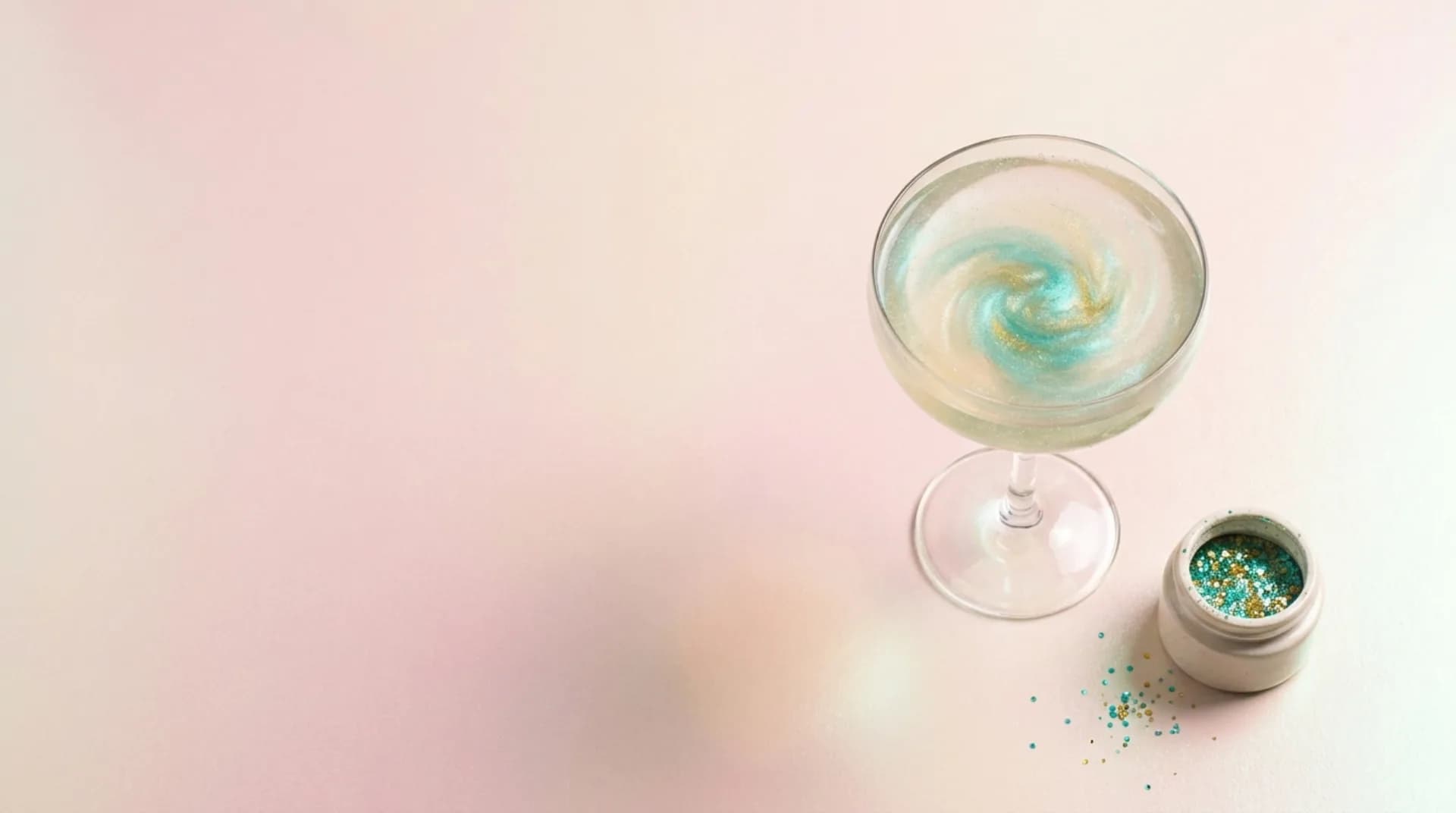 Une coupe où tourne un voile de paillettes turquoise, le pot ouvert posé à côté